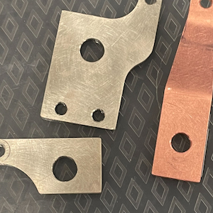 two nickel-plated copper parts and one unplated copper part