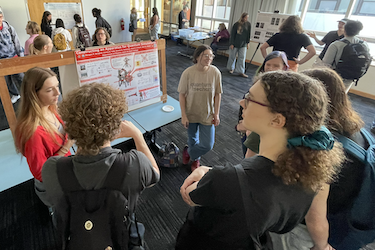 Morgan and Emma H present a poster to other students